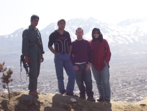 Andrea Muto standing next to an American project colleague, a driver, and a military guard on top of a mountain in Kabul, Afghanistan, in 2007. 