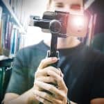 Photo: Man holding a video camera in the library
