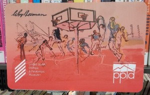Pikes Peak Library District card depicting basketball players in honor of the US Olympic and Paralympic Museum