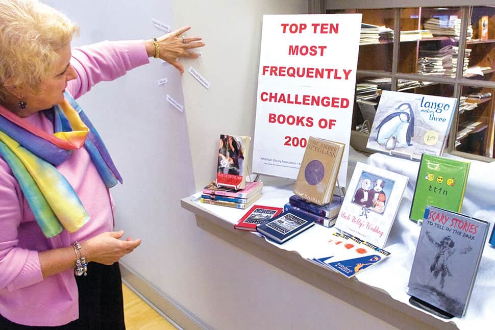 Jo Roussey, director of volunteer services at York County (Pa.) Libraries’ Martin branch, sets up a display of the top 10 books most frequently challenged or requested to be removed from libraries last year.