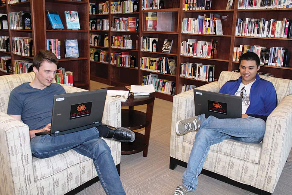 Utah Lambert (left) and Jonathan Manning use the new laptops available for checkout at Anythink Brighton in Colorado.