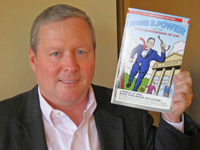 ProQuest CEO Kurt Sanford, holding a comic celebrating the 75th anniversary of microfilm. Photo: George M. Eberhart