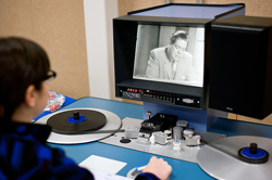 A patron at the Indiana University Library Film Archive uses a flatbed viewer to watch a 16mm archival film.
