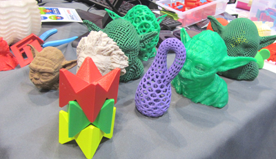 Several Yoda heads mingle with other 3D-printed object d'art at Maker Monday