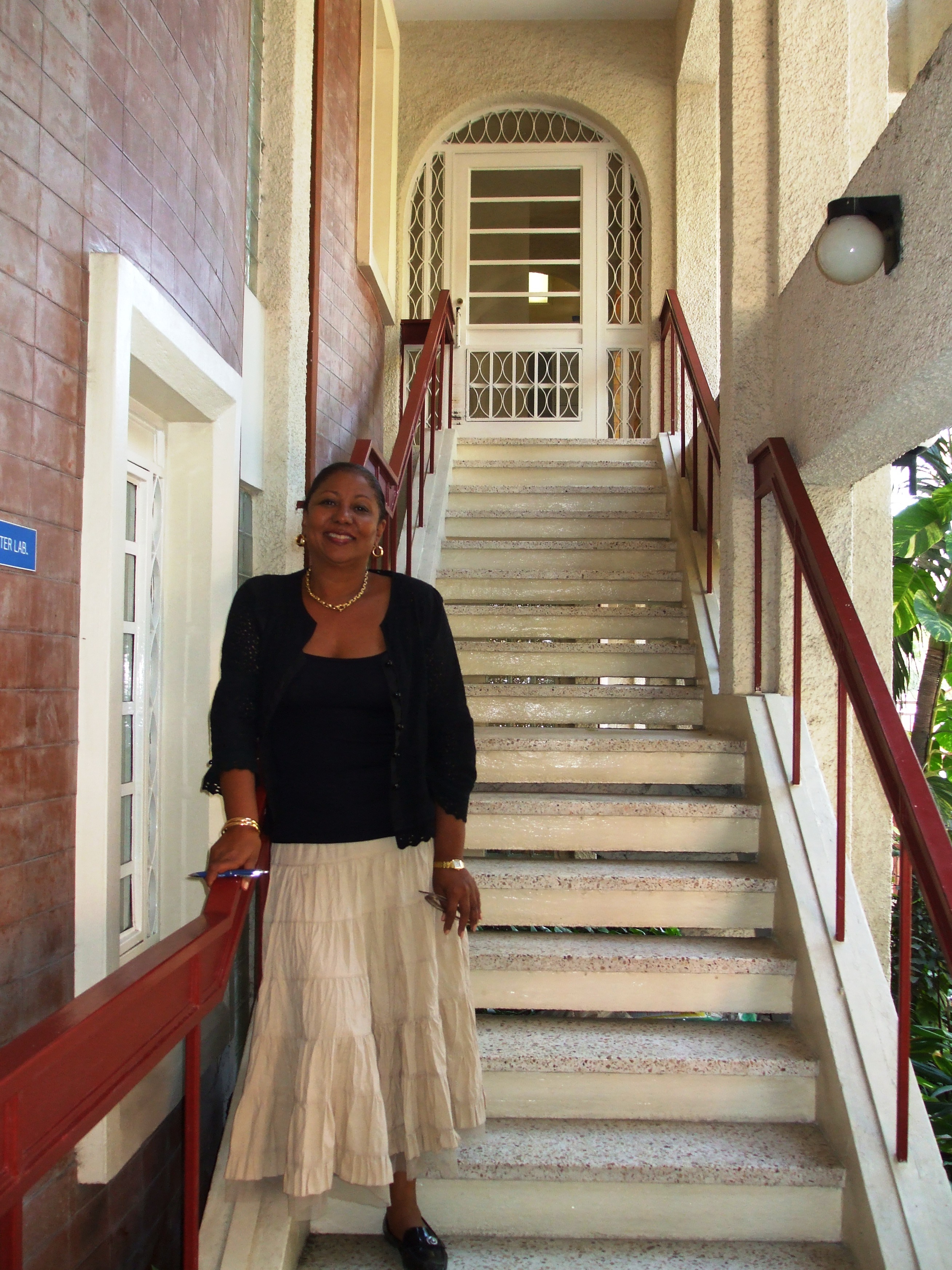 The main building of the Haitian American Institute—where director Francoise Beaulieu-Thybulle poses on the stairway—survived the quake but its historic library was lost. 