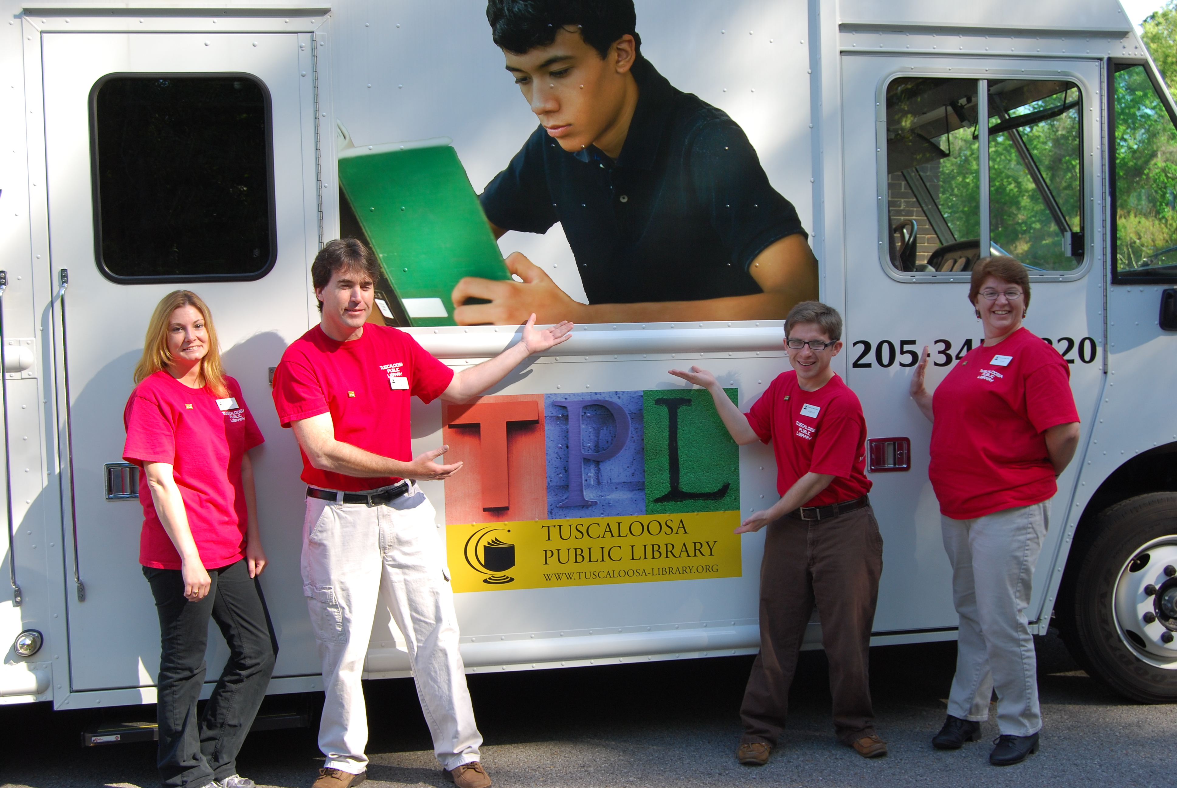 Staffers (left to right) Tammy Adams, Kelly Butler, Addison Canevaro, and Lynn Allen show off the Tuscaloosa (Ala.) Public Library bookmobile during National Bookmobile Day April 13, as part of NLW.