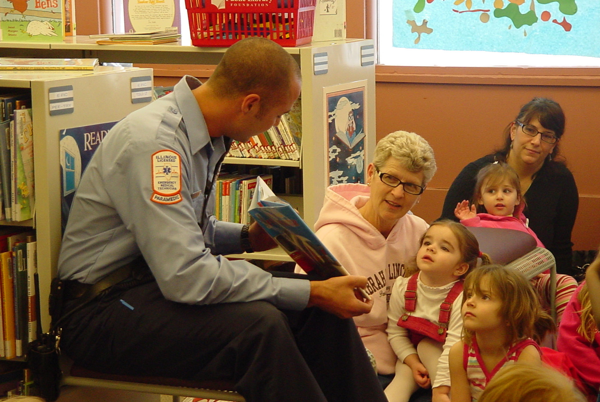 Rock Island firefighter Chad Chindlund of the Central Fire Station reads to children at Rock Island (Ill.) Public Library’s 30/31 branch. The library’s Children’s Department hosted special “Community Helper” storytimes with volunteer readers from the police and fire departments.