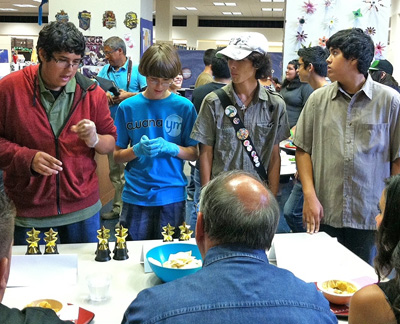 Teens Austin (left), Benjamin, Noe, and Adam reveal their salsa-making secrets to the “Pica! Salsa Throwdown” judges at the San Antonio Public Library contest. (Pica translates roughly from Spanish to English as spicy.)