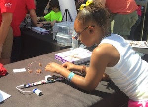 A young girl playing with a Little Bits electronics kit at SX Create.