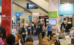 The author (left center) chats with an OCLC rep in the busy exhibit hall (photo: OCLC).