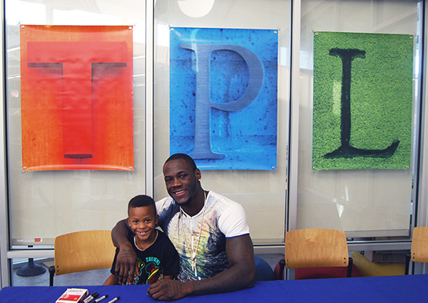 World Boxing Council world heavyweight champion Deontay Wilder with Tuscaloosa (Ala.) Public Library patron Jaden Williams during Wilder’s book signing. (Photo: Vince Bellofatto)