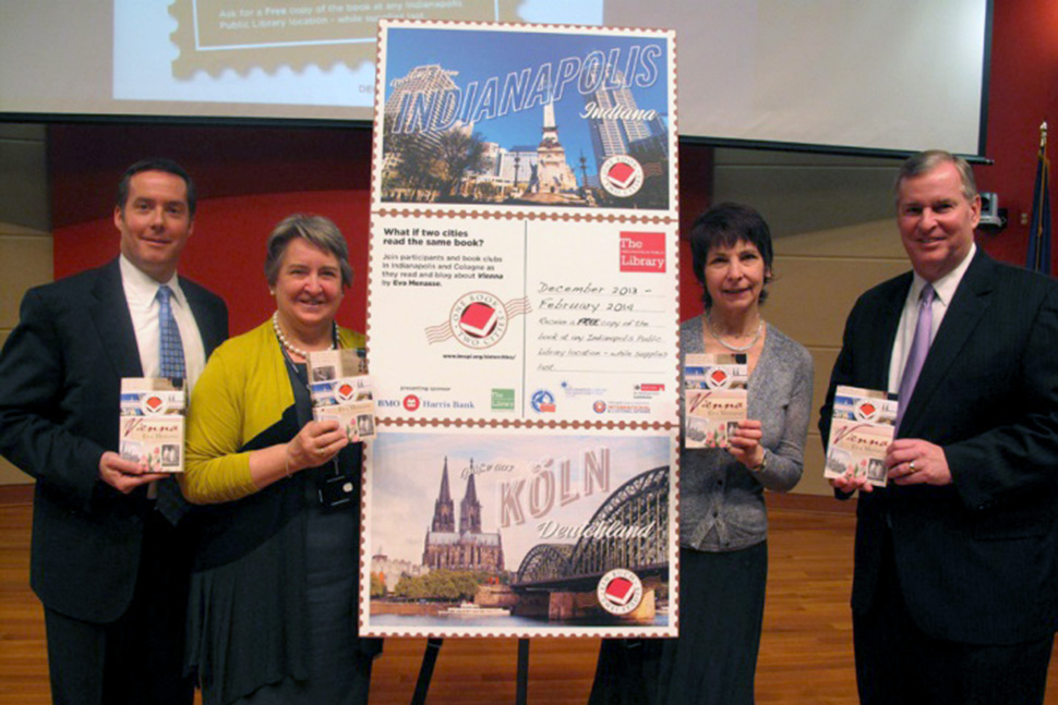 (left to right) Andy Cardimen, BMO Harris Bank managing director, Jackie Nytes, Indianapolis Public Library chief executive officer, Chris Cairo, director of project development at Indianapolis–Marion County Public Library, and Greg Ballard, mayor of Indianapolis, hold the One Book, Two Cities book selection, Vienna by Eva Menasse, at the program’s launch in December 2013. Photo: Indianapolis Public Library