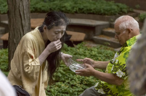 Eiko Otake offers a bowl of water to Russell Library Director Arthur Meyers. Otake’s performances often allow audience members to participate and react to elements of the dance.