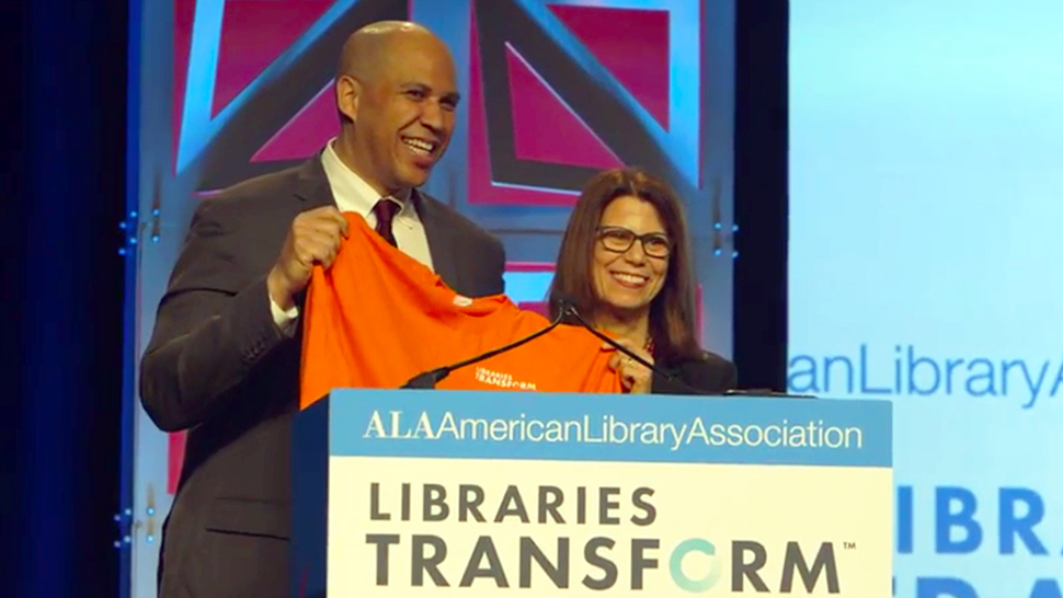 ALA President Sari Feldman presents Sen. Cory Booker a Libraries Transform t-shirt.