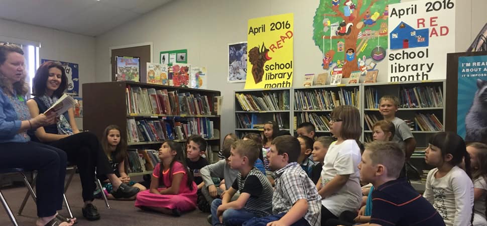 Author Megan McDonald (far left) reads to kids during a School Library Month event.