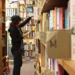 A volunteer with Books to Prisons Seattle searches the donated books to fulfill prisoner requests.