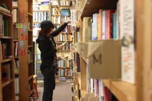 A volunteer with Books to Prisons Seattle searches the donated books to fulfill prisoner requests.