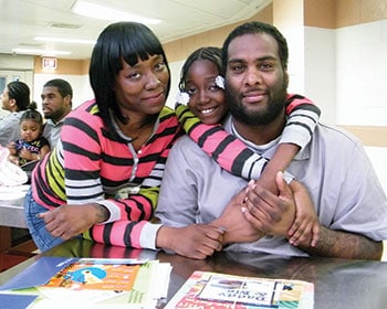 A family poses at the Daddy and Me program’s family day event, facilitated at a jail by Brooklyn (N.Y.) Public Library. (Photo: Brooklyn Public Library)