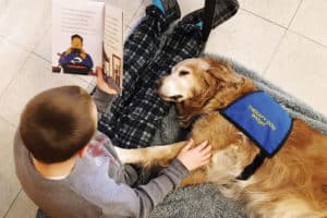A Bedford, Indiana, student reads on pajama day at school to Bridget, a therapy dog owned by Mary Hall of Bedford Public Library. Photo: Mary Hall/Bedford (Ind.) Public Library