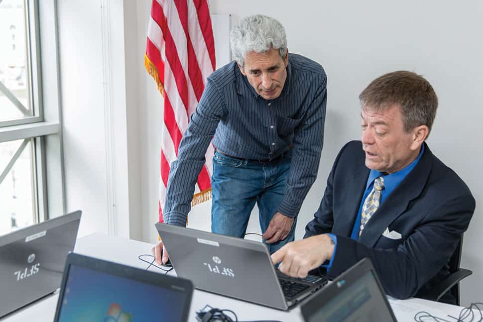 A volunteer (left) helps a veteran at San Francisco Public Library’s Veterans Resource Center. The center is part of the Veterans Connect @ the Library program. Photo: Jason Doiy