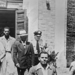 An officer escorts five men from the Alexandria (Va.) Library in August 1939. They were arrested and charged with disorderly conduct.