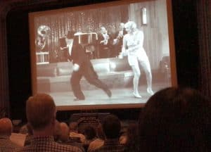 Audience members view a clip from the RKO film Peach O’ Reno with Bert Wheeler and Dorothy Lee. 