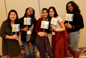 Interns pose with Inclusive Internship Initiative signs at the commencement event in Chicago on October 14. (Photo: Tori Soper)