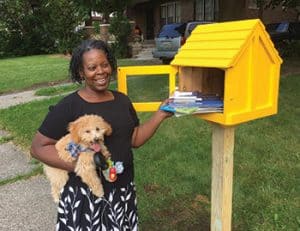 Kathy Henderson stands next to a Little Free Library in Highland Park, Michigan. Photo: Detroit Little Libraries