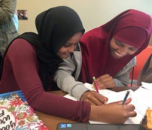 Ayan Ismail (left) and Hikmo Abdi, 10th graders at Roosevelt High School in Minneapolis, work on geometry homework at Hennepin County Library’s Roosevelt Library. 
