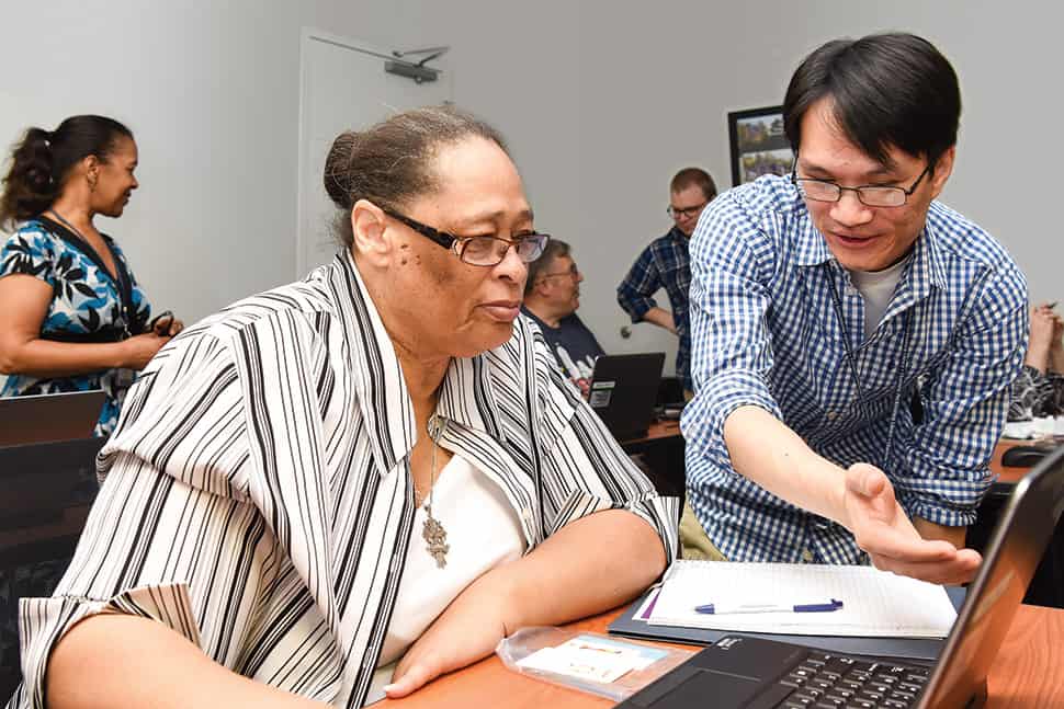 Staff members of Charlotte Mecklenburg (N.C.) Library assist seniors at a YMCA DigiLit class designed to help bridge the digital knowledge divide.Photo: Everett Blackmon