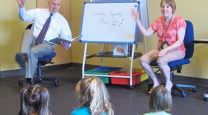 Rep. Tom Emmer (R-Minn., left) reads to a group of children at Great River Regional Library in St. Cloud with LuAnne Chandler, patron services associate. Photo: Abby Faulkner