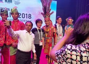 IFLA delegates take to the stage to pose for photos with Malay dancers.after the Opening Session