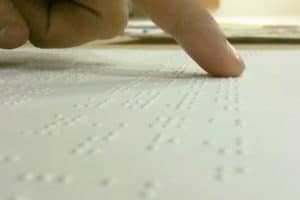 Fingertips reading a Braille manuscript