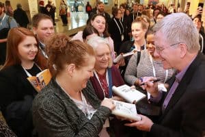 Attendees crowd around travel author Rick Steves for autographs following his Auditorium Speaker Series presentation at the 2019 ALA Midwinter Meeting. Photo: Cognotes