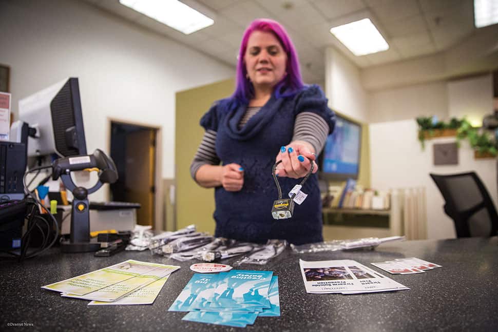 Stephanie Jewett, manager at Salt Lake County Library’s Columbus branch, displays a gun lock available at the library. (Photo: Qiling Wang/Deseret News)