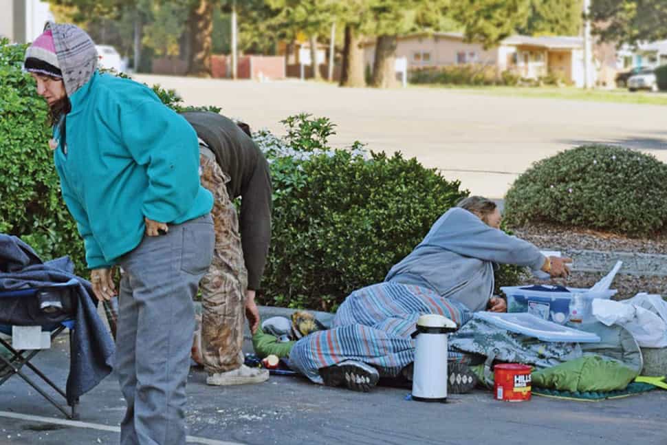 Campers prepare to remove personal belongings from the parking lot of Chetco Community Public Library in Brookings, Oregon, after the library board voted to prohibit the use of tents, tarps, structures, and furniture on library grounds. (Photo: Boyd C. Allen/Curry Coastal Pilot)