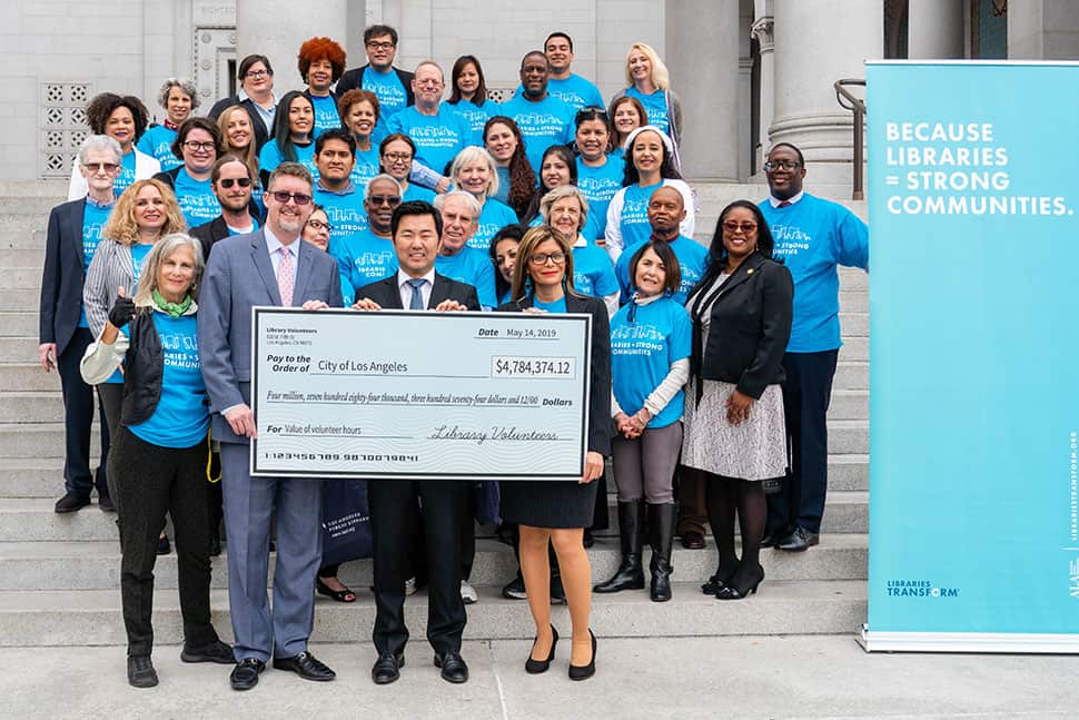 Los Angeles City Librarian John Szabo (front row, from left), Councilmember David Ryu, and ALA President Loida Garcia-Febo hold a giant check for nearly $4.8 million, symbolizing the efforts of the nearly 7,500 volunteers who contributed 164,000 hours of work in Los Angeles Public Library's 73 locations in 2018. Photo: Los Angeles Public Library
