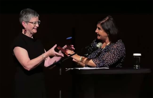 Incoming IFLA President Christine Mackenzie (left) accepts the gavel from outgoing President Glòria Pérez-Salmerón during the Closing Session in Athens, Greece, August 29.