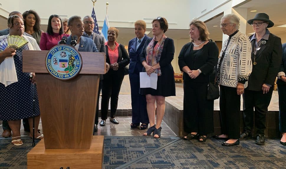 Chicago Mayor Lori Lightfoot (behind podium) announces the elimination of late fees throughout the Chicago Public Library system on September 30 at Woodson Regional Library with CPL Commission Andrea Telli (center, holding paper) and American Library Association Executive Director Mary Ghikas (right). (Photo: Stephanie Hlywak/American Library Association)