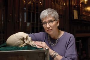 Beth M. Lander, college librarian at the Historical Medical Library of the College of Physicians of Philadelphia, poses with a human skull set on green velvet. (Photo: Kriston Bethel)