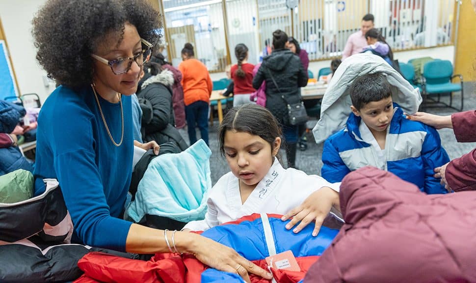 A librarian helps a child pick out her new coat at Chicago Public Library's Chicago Lawn branch. (Photo: Francis Son)