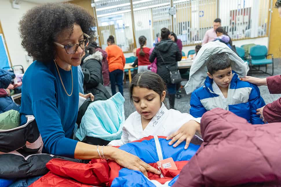 A librarian helps a child pick out her new coat at Chicago Public Library's Chicago Lawn branch. (Photo: Francis Son)