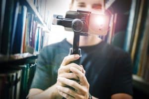 Photo: Man holding a video camera in the library