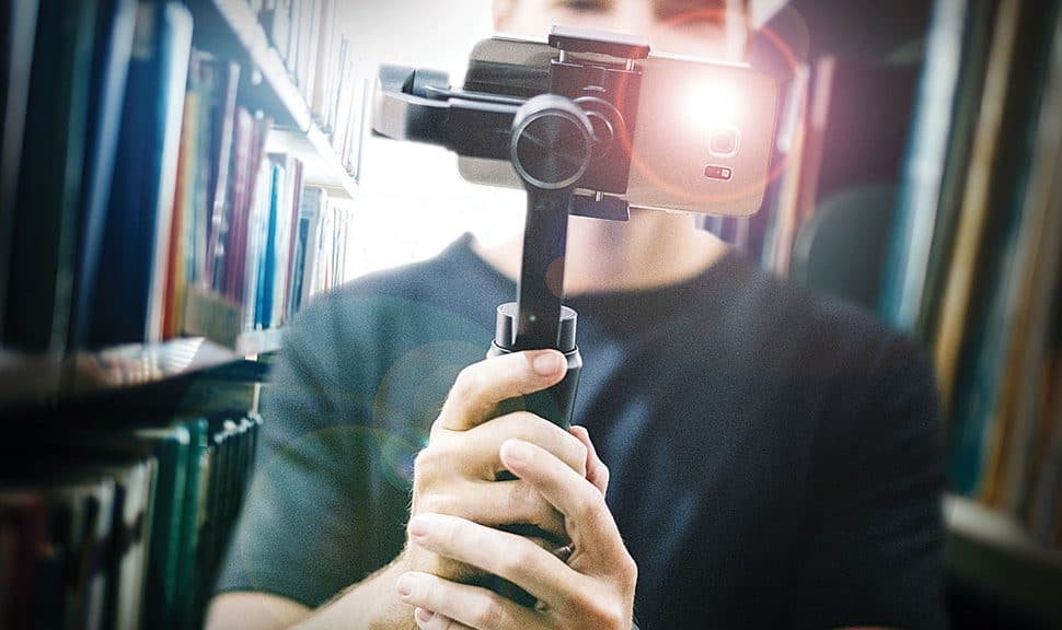 Photo: Man holding a video camera in the library