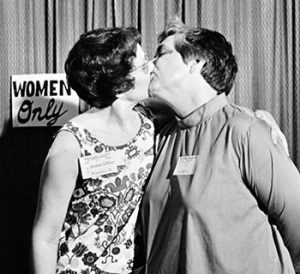 Barbara Gittings and author Alma Routsong kiss each other at the Task Force on Gay ­Liberation’s Hug-a-Homosexual booth in the exhibit hall at ALA’s 1971 Annual Conference in Dallas. Photo: ALA Archives
