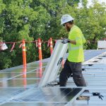 A worker installs solar panels on the roof of Ledding Library in Milwaukie, Oregon. Photo: Katie Newell/Ledding Library in Milwaukie, Oregon