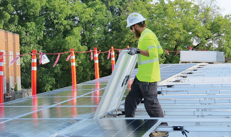 A worker installs solar panels on the roof of Ledding Library in Milwaukie, Oregon. Photo: Katie Newell/Ledding Library in Milwaukie, Oregon