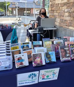 In La Grande, Oregon, Cook Memorial Library Teen Services Librarian Celine Vandervlugt takes a turn staffing Library Take-Out(side), a service that allows patrons to browse materials outdoors.