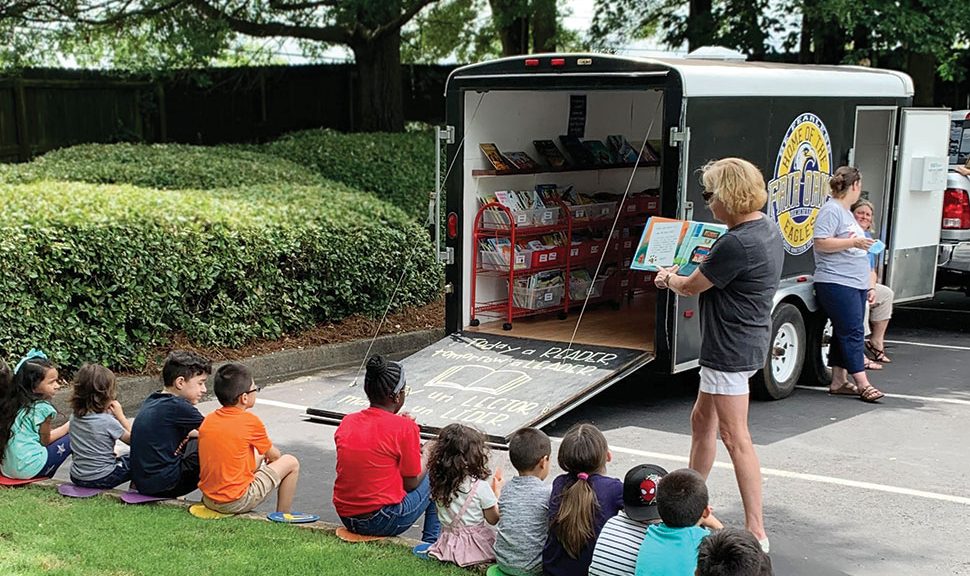 Valerie Wagley, counselor at Fair Oaks Elementary School in Cobb County, Georgia, reads to kids at a bookmobile stop in summer 2020. Photo: Kelli Wood
