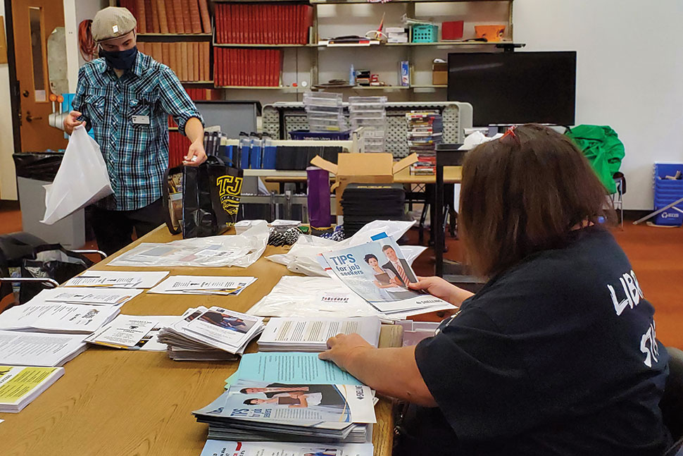 Reference Desk Associate T. J. Rankin (left) and Circulation Supervisor Brenda Choy create "job fairs in a bag" at Tyler (Tex.) Public Library. Photo: Tyler (Tex.) Public Library